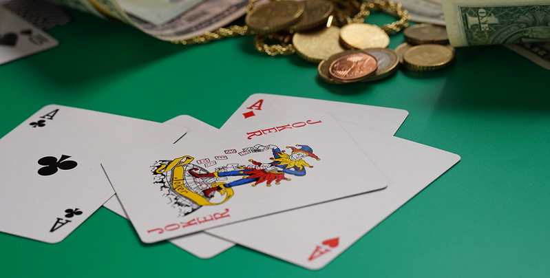 cards including joker on a table with money close up